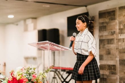 A girl in a skirt is holding a microphone