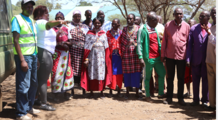 A group of people standing in front of trees.