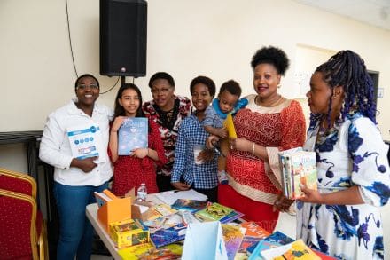 A group of people standing around a table with books.